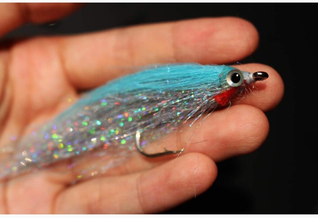 A Tigofly streamer fly with vibrant yellow, orange, blue, fuchsia, green, silver, and purple colours, rated 4.4 out of 5 stars for salmon and trout fly fishing.