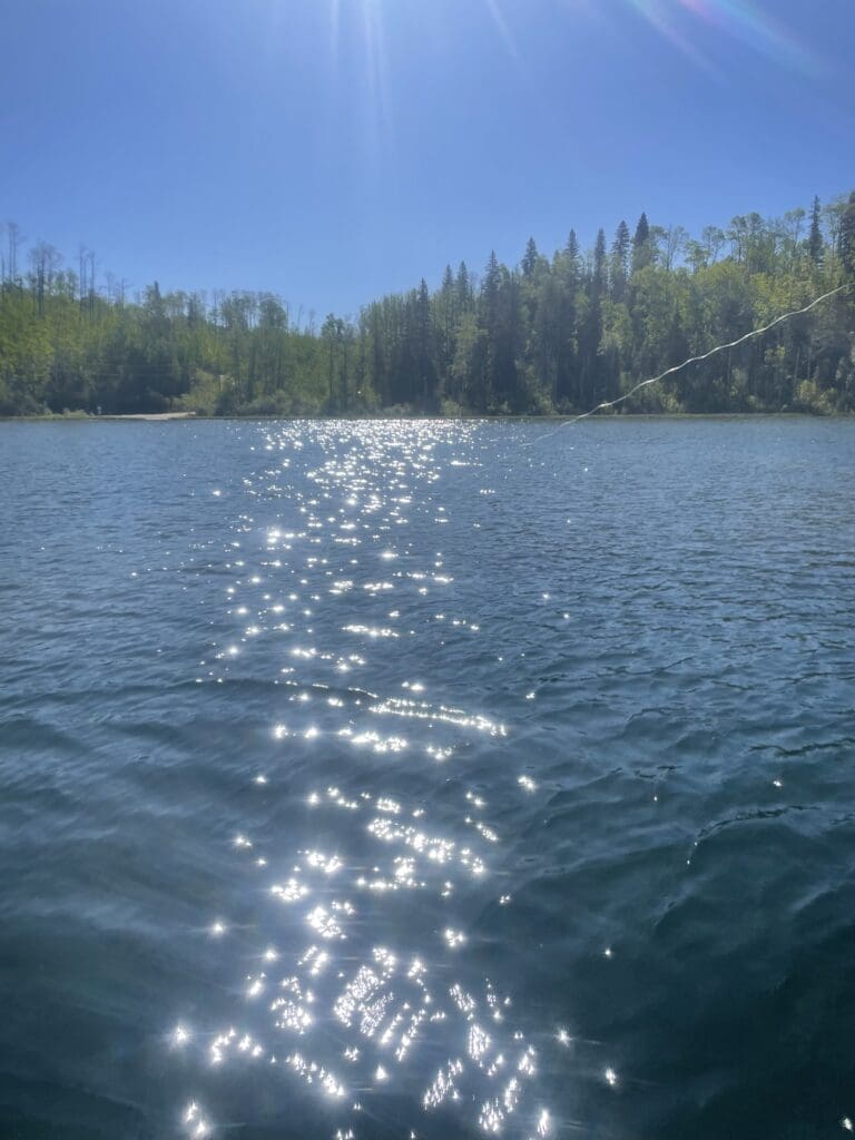 Mitchell Lake sparkling like diamonds with a fishing line in the water.