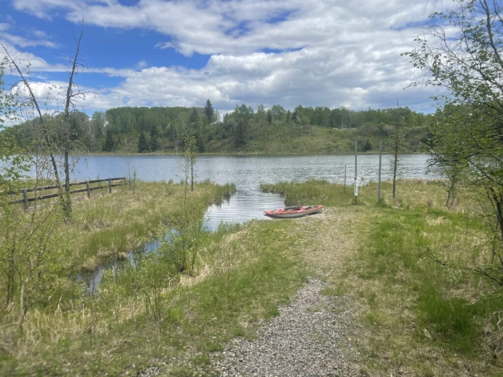 View of Ironside Pond from the walking path, with a kayak at the launch point.
